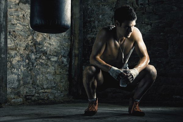 Caucasian boxer drinking water after training