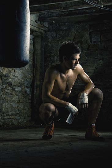 Caucasian boxer drinking water after training