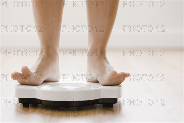 Caucasian woman's feet standing on scale