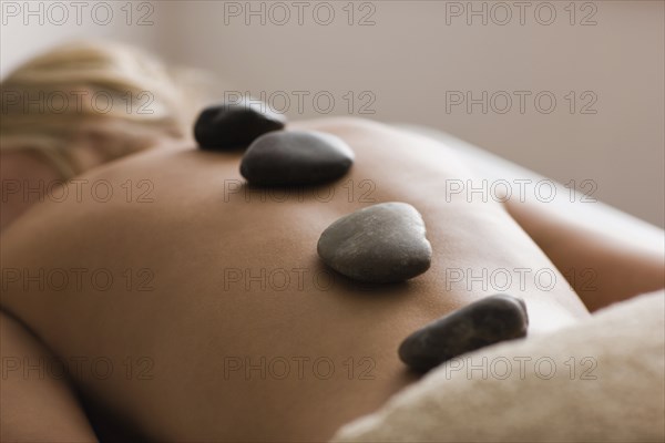 Caucasian woman receiving hot stone massage