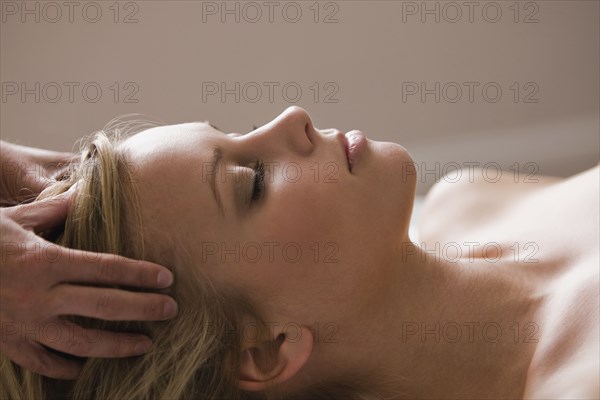 Caucasian woman receiving head massage