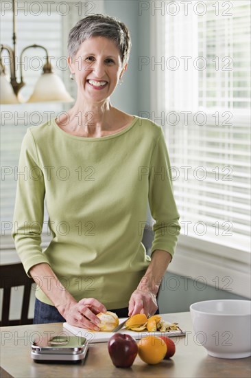Senior woman cutting fruit