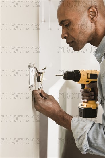 African American man using cordless drill