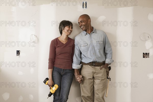 Couple holding hands in unfinished room