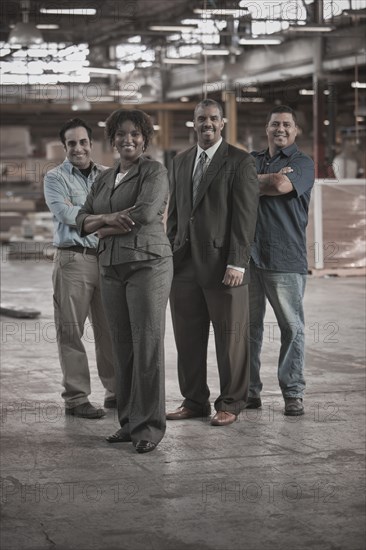 Business people and workers standing in warehouse