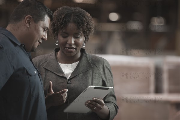 Businesswoman talking to worker in warehouse