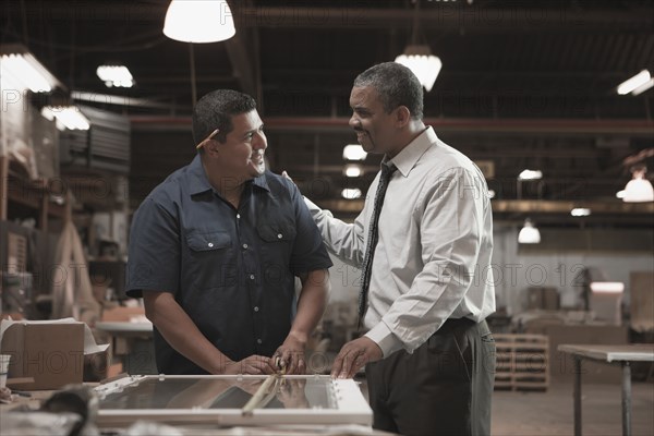 Businessman talking to worker in warehouse