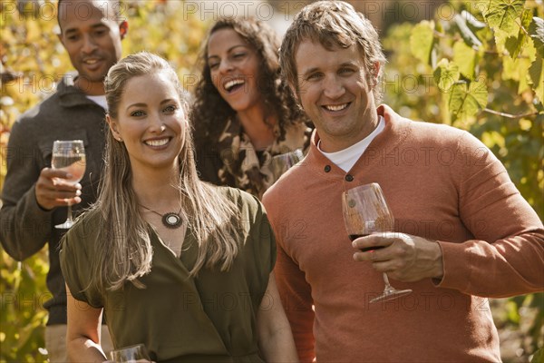 Friends drinking wine in vineyard