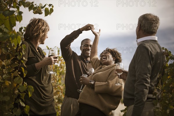 Friends drinking wine in vineyard