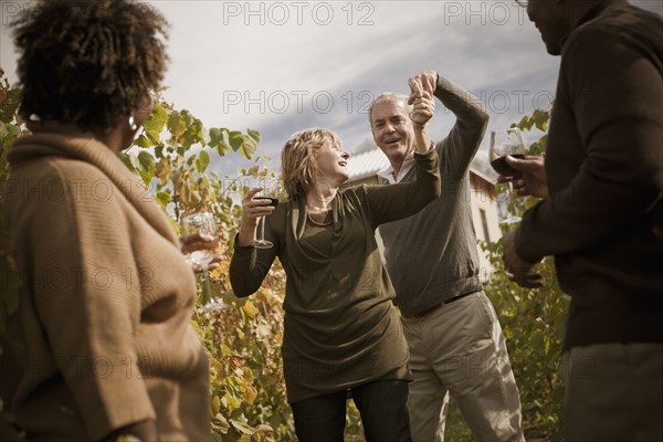 Friends drinking wine in vineyard