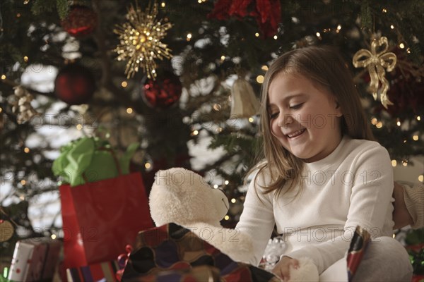 Mixed race girl opening gifts Christmas morning