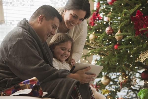 Family looking at digital tablet on Christmas morning