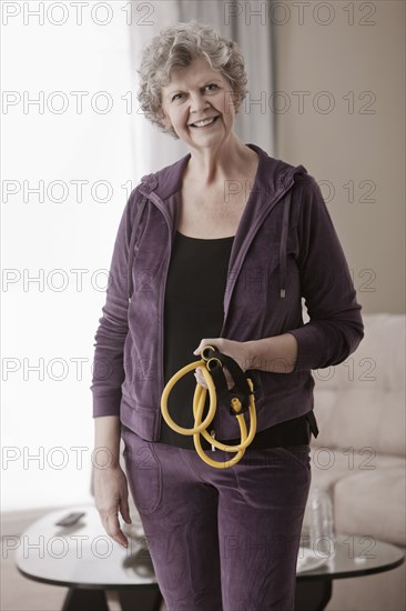 Caucasian woman holding exercise bands in living room