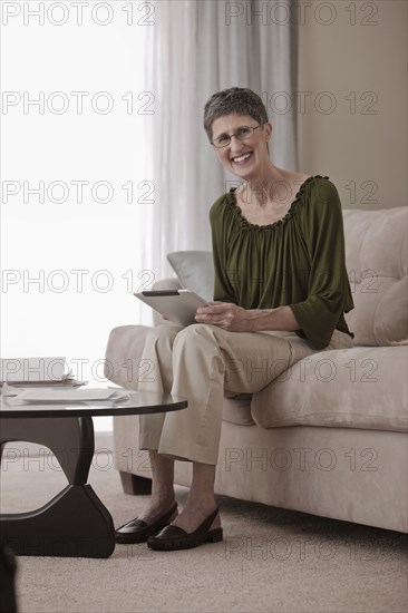 Caucasian woman using digital tablet on sofa