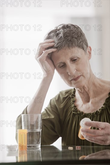 Confused Caucasian woman looking at prescription bottle