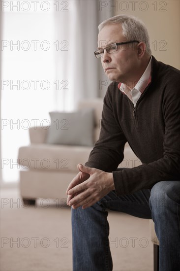 Serious Caucasian man sitting in living room