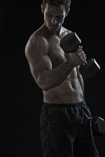 Caucasian man exercising with hand weights