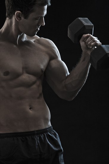 Caucasian man exercising with hand weights