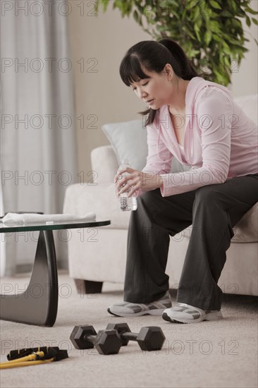 Asian woman drinking water after exercise