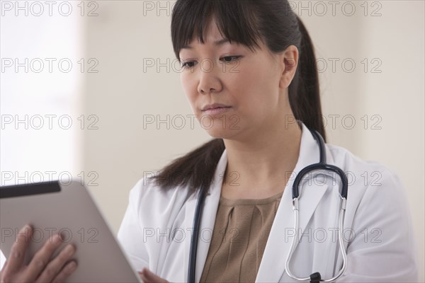 Asian doctor using digital tablet