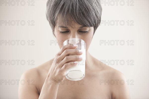 Mixed race woman drinking milk