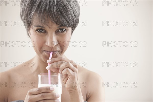 Mixed race woman drinking milk