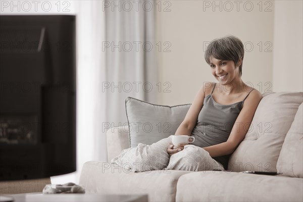 Mixed race woman relaxing on sofa