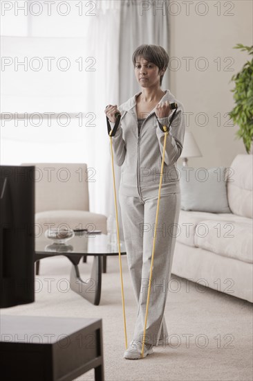 Mixed race woman exercising in living room