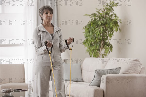 Mixed race woman exercising in living room