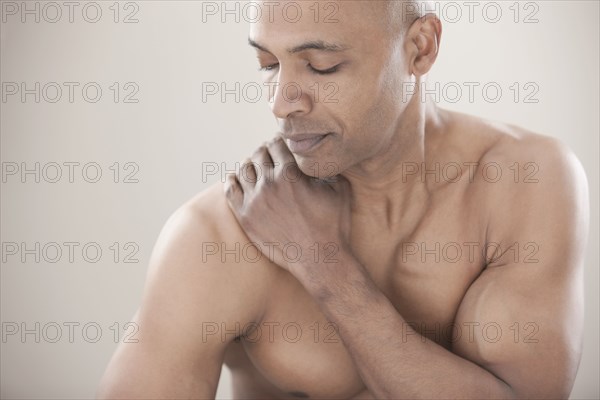 Black man rubbing his shoulders