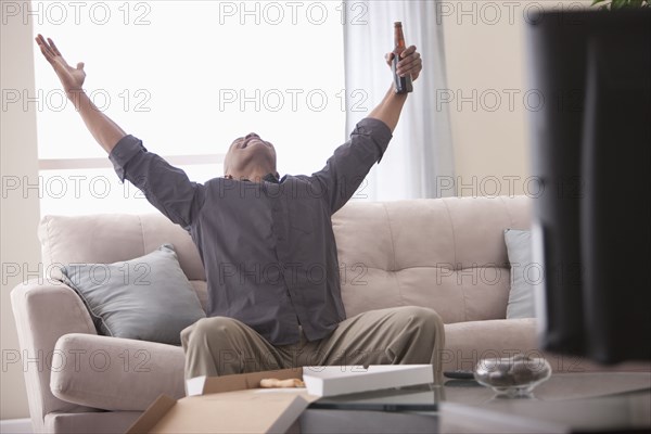 Black man cheering and watching television