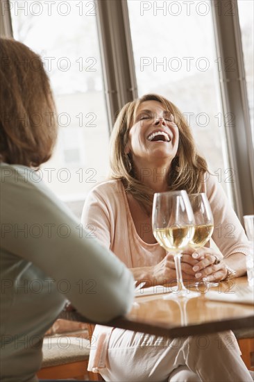 Caucasian friends drinking wine in restaurant