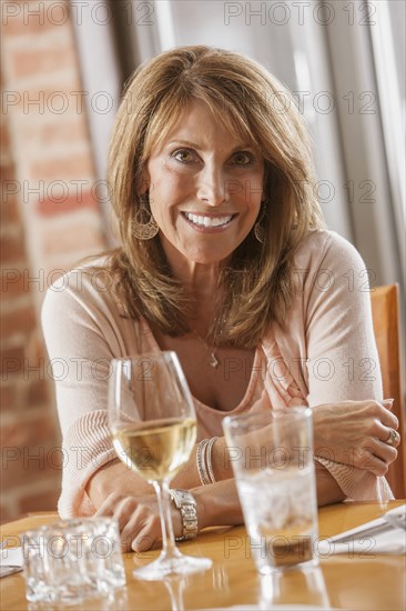 Caucasian woman drinking wine in restaurant