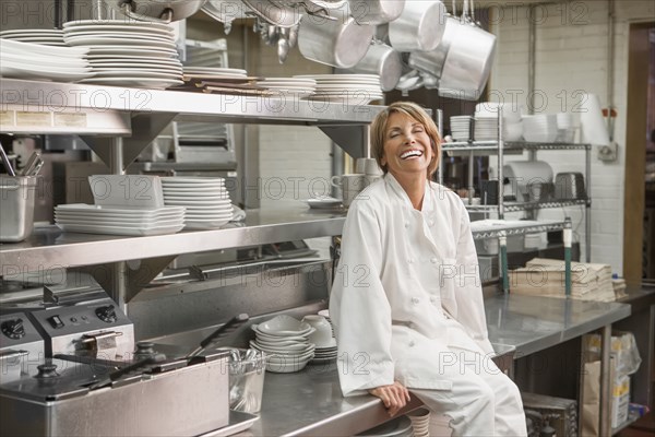 Caucasian chef sitting in commercial kitchen