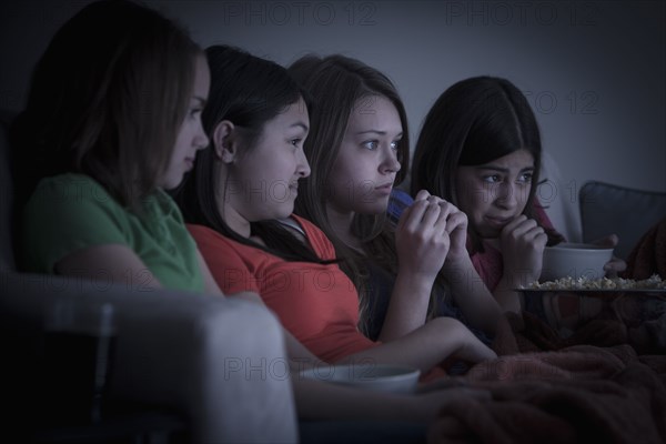 Friends eating popcorn and watching a movie