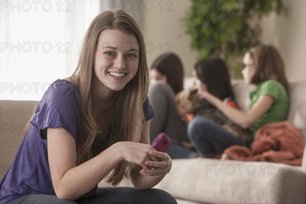 Smiling girl holding cell phone