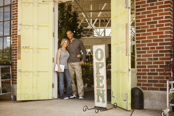 Couple standing in flower shop doorway