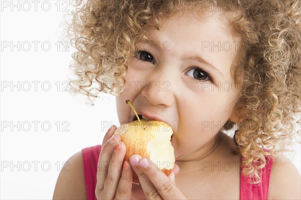 Mixed race girl eating apple