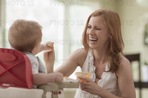 Caucasian mother feeding son
