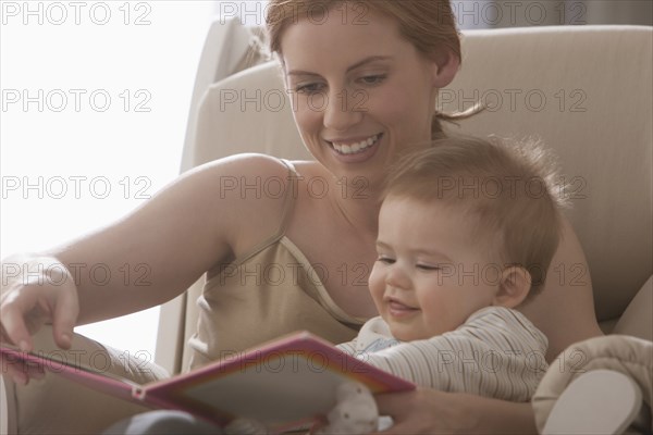 Caucasian mother reading book to son