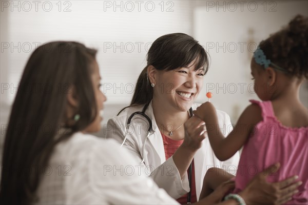 Doctor handing girl lollipop