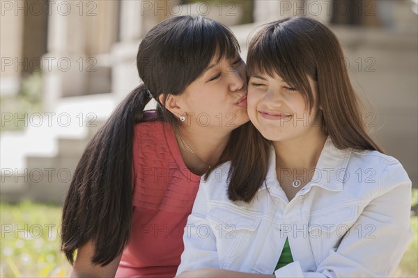 Mother kissing daughter