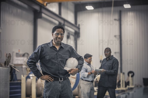 African American worker standing in factory