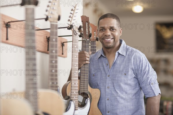 Native American man holding guitar in music store