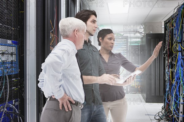 Business people working in server room