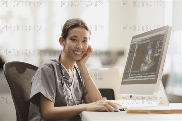 Mixed race nurse using computer