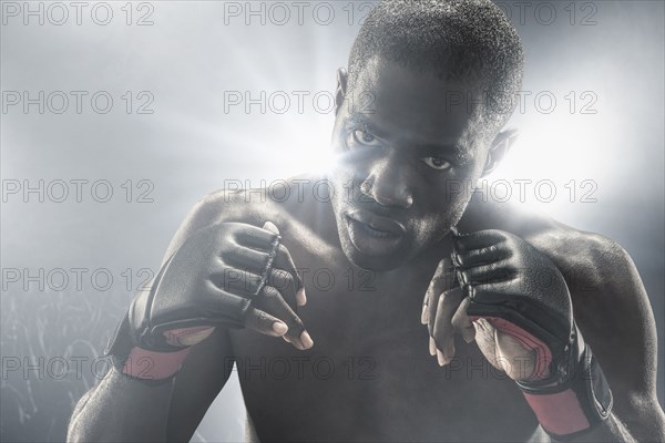 African American MMA boxer with gloves raised