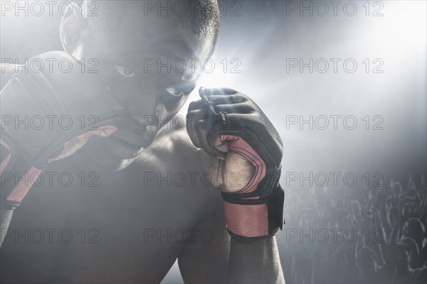 African American MMA boxer with gloves raised