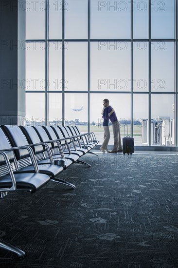 Caucasian couple hugging in airport