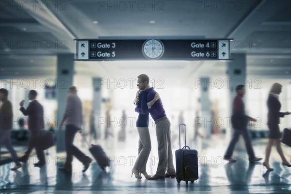 Caucasian couple hugging in airport